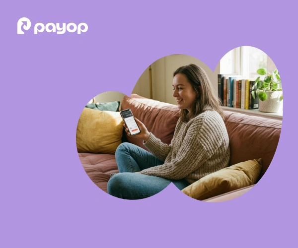 A woman smiles as she looks at her phone, sitting on a couch with yellow cushions. The image has a purple background and "PayOp" logo in the corner.