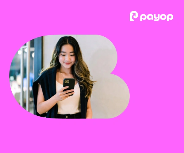 A woman smiles as she looks at her phone. She appears calm and content. The background is pink, with the Payop logo in the top-right corner.