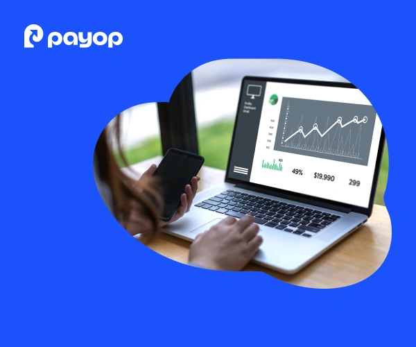 Person using a smartphone and laptop displaying a graph with statistics, set against a blue background with the Payop logo in the top left corner.