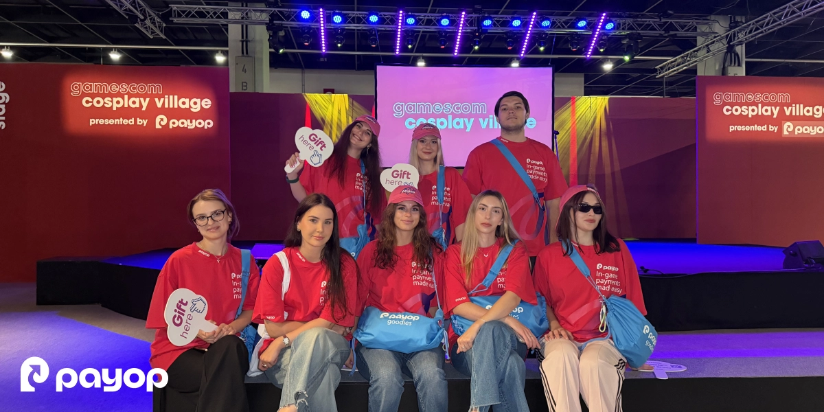 Payop team members in matching red t-shirts at the Gamescom 2026 Cosplay Village stage.