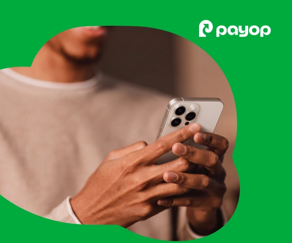 Person holding a smartphone for mobile checkout against a vibrant green Payop background
