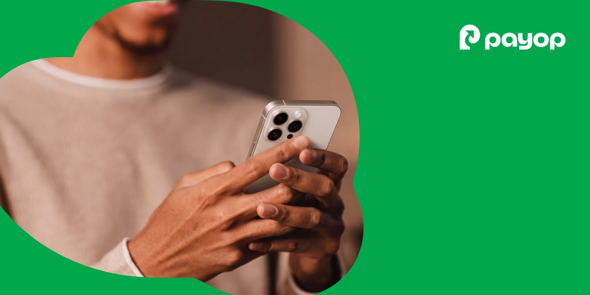 Person holding a smartphone for mobile checkout against a vibrant green Payop background
