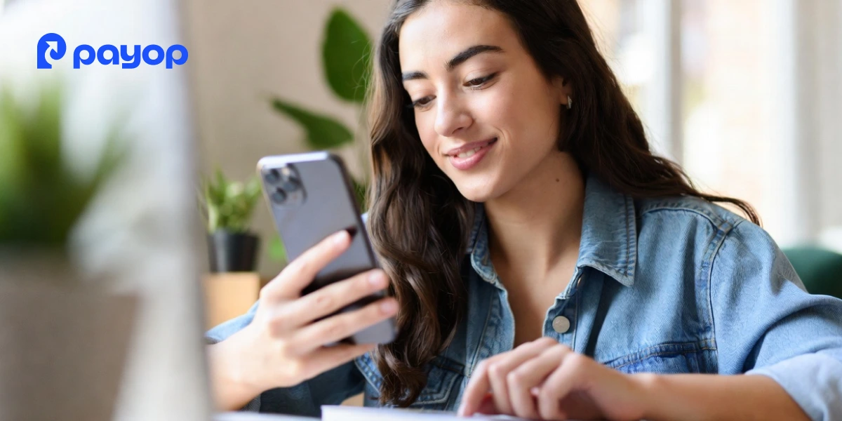Woman using a smartphone for open banking payments, representing faster payments and real-time settlement through mobile banking