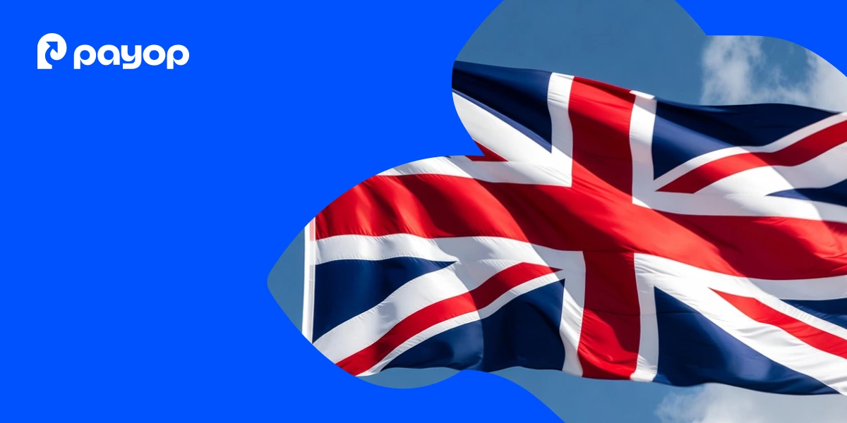 The image features a waving Union Jack flag set against a blue abstract background. The Payop logo is displayed in the top left corner.